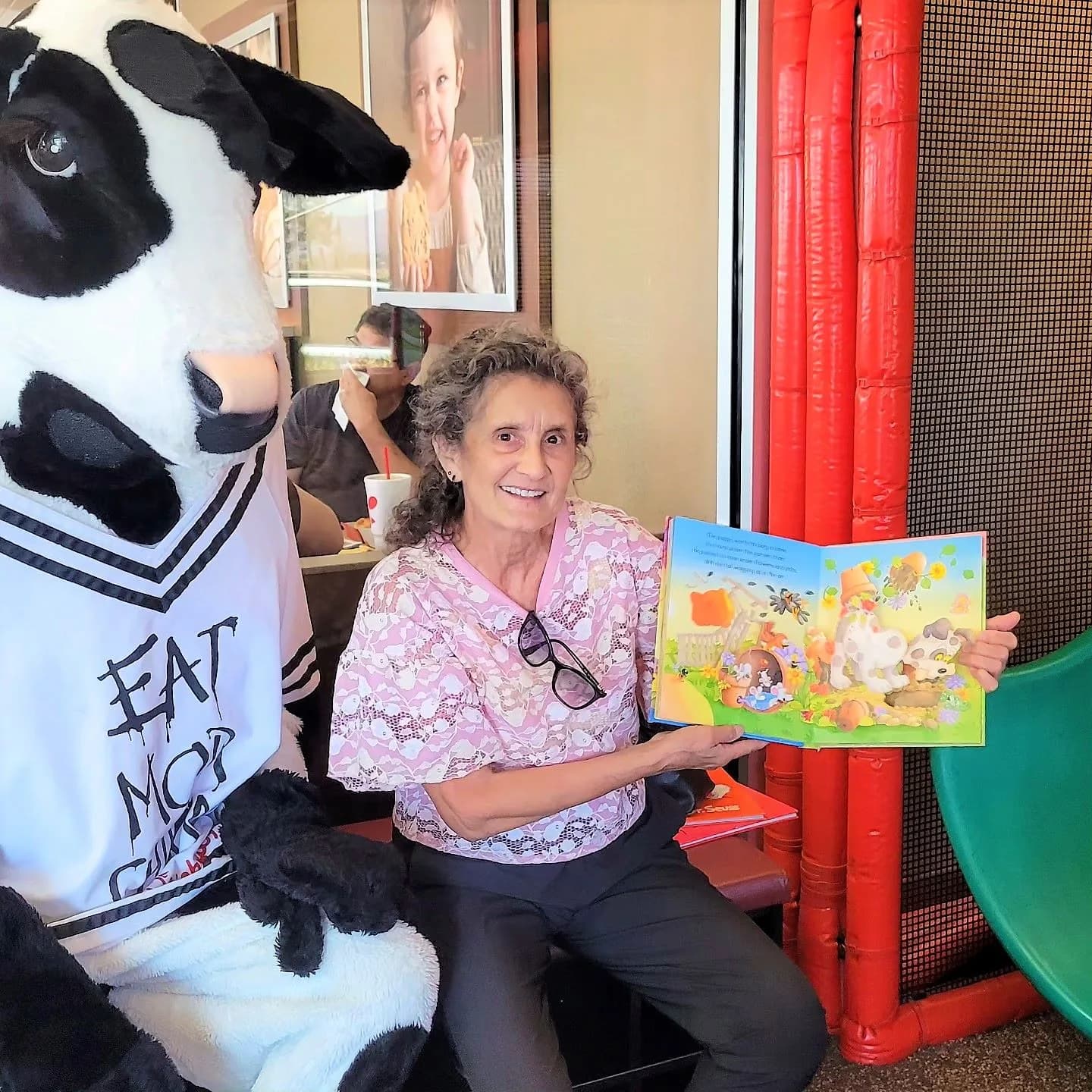 Smiling children with the Chick-fil-A cow mascot during a reading event