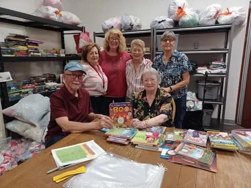 Volunteers and Rotarians sorting donated books around a table