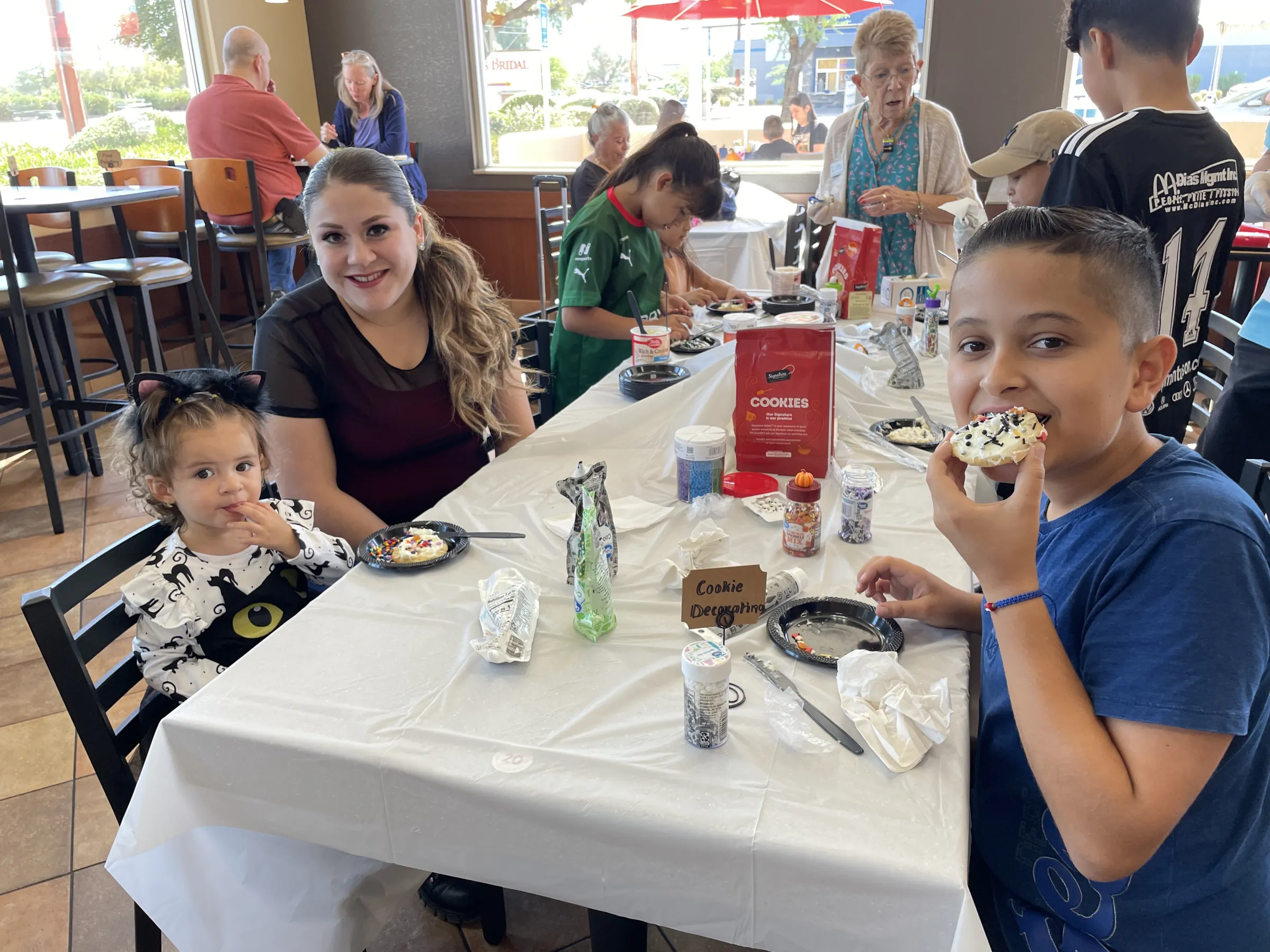 A family decorating cookies together at an Angel Heart community event