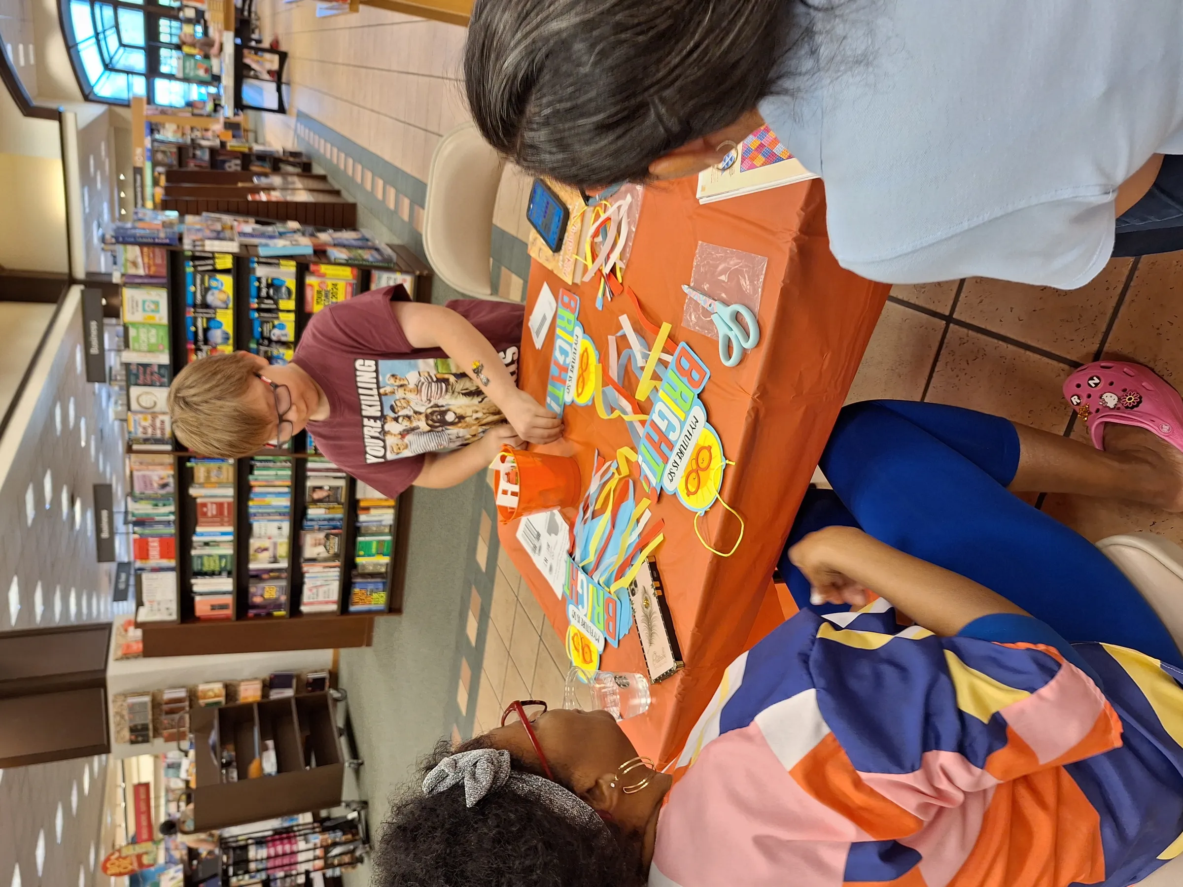 A child working on a craft at an Angel Heart book fair inside a bookstore