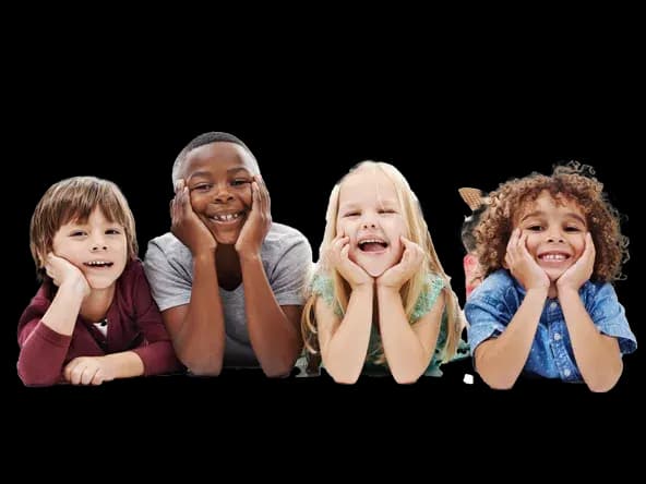 Four smiling children lying on their stomachs, chins in their hands